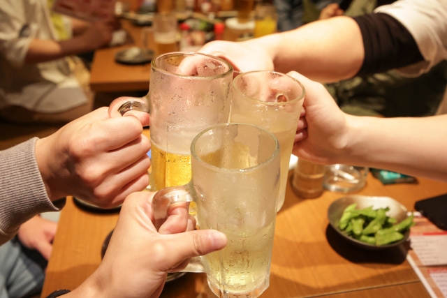 居酒屋でジョッキで乾杯する手
