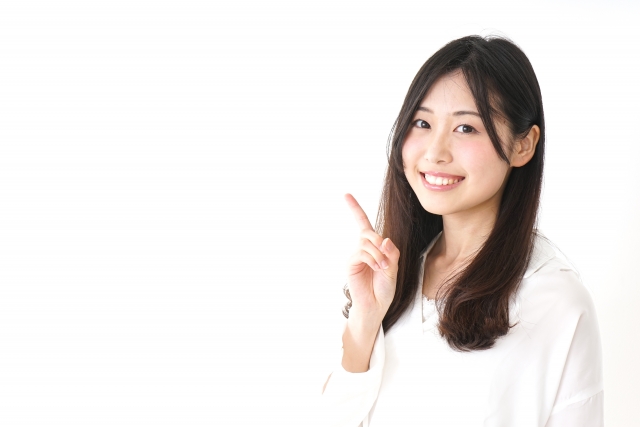 指を立てて微笑む女性